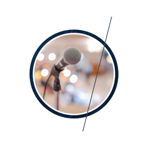 A microphone on a stand in front of a lit auditorium